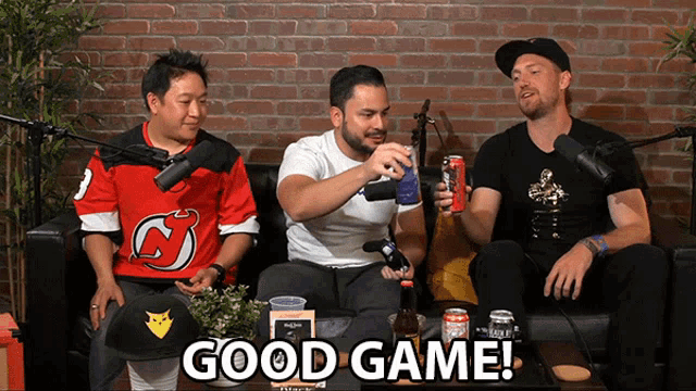 a group of men are sitting on a couch and one of them is wearing a jersey that says devils