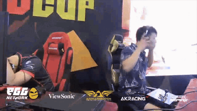 a man is sitting in front of a screen that says u cup