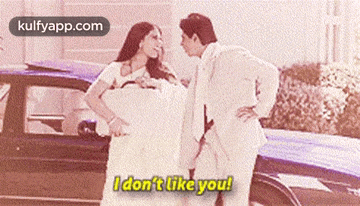 a man and a woman are standing in front of a car and the woman says i don 't like you