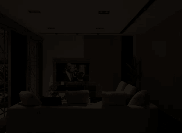 a dark living room with a white couch and a tv