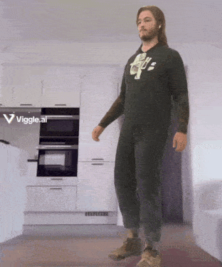 a man is standing in a kitchen wearing a t-shirt that says ' us ' on it