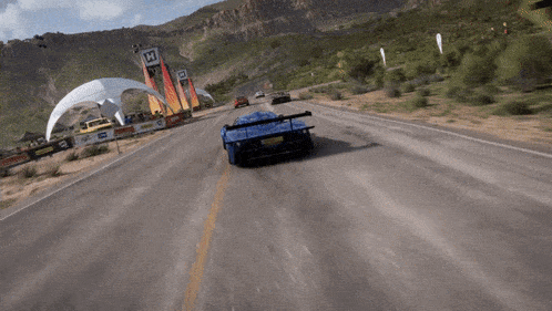 a blue sports car is driving down a road with a sign that says h