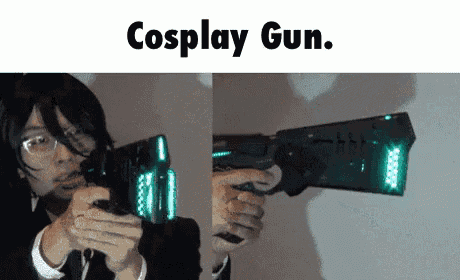 a man in a suit is holding a cosplay gun .