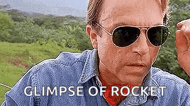 a man wearing sunglasses and a denim shirt is making a funny face and says glimpse of rocket .