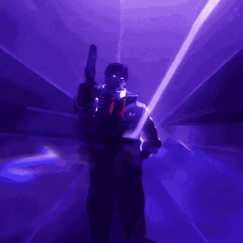 a person is holding a gun in a dark room with purple lights behind them