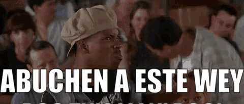 a man wearing a hat is sitting in front of a crowd of people and says abuchen a este wey .