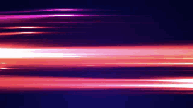a purple and pink light beam is moving in the dark .