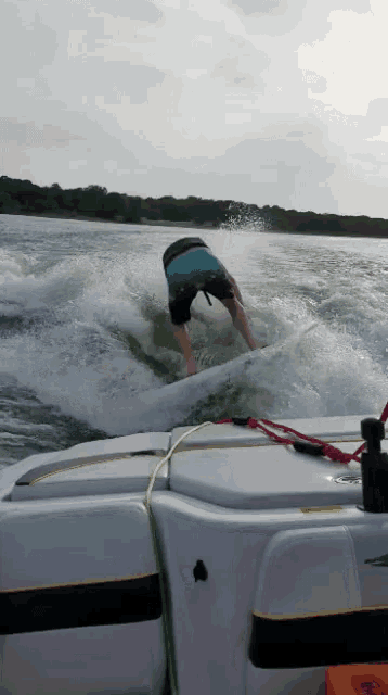a person is riding a wave on a boat with a life jacket on the back