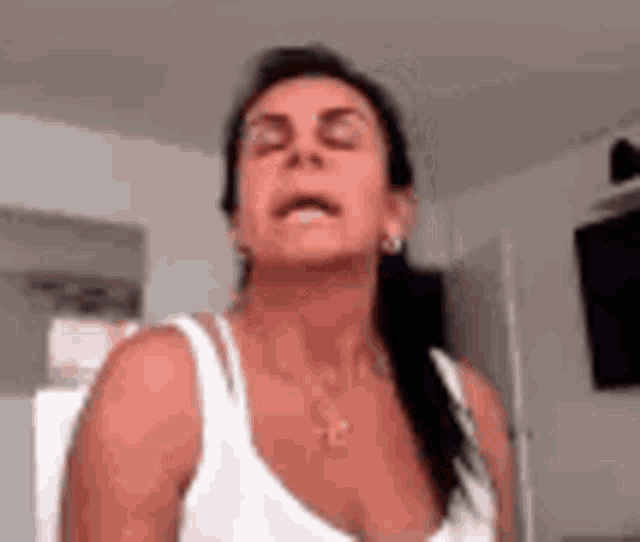 a woman is making a funny face with her eyes closed and her mouth open .