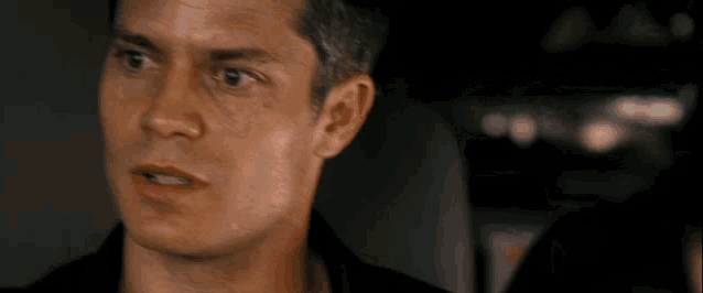 a close up of a man 's face with a black shirt