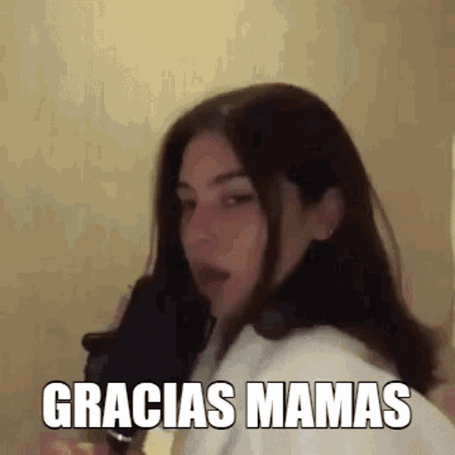 a woman is standing in front of a microphone with the words gracias mamas written on her face .