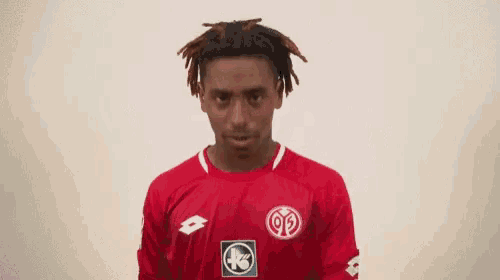 a man wearing a red shirt with lotto on it