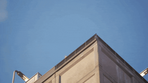 a large concrete building with a blue sky in the background