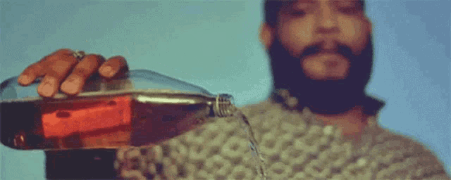 a man with a beard is pouring soda into a glass