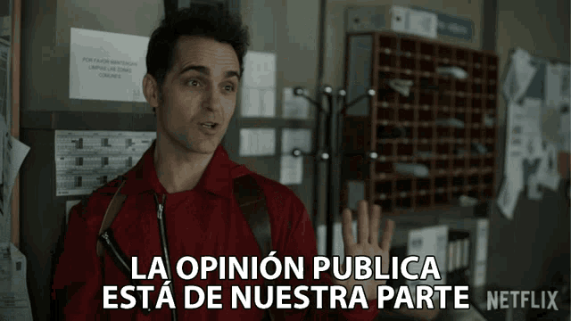 a man in a red jacket stands in front of a sign that says la opinion publica esta de nuestra parte