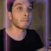 a close up of a man 's face with a purple light behind him