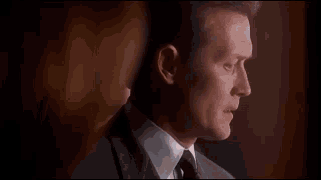 a close up of a man in a suit and tie looking at a woman .