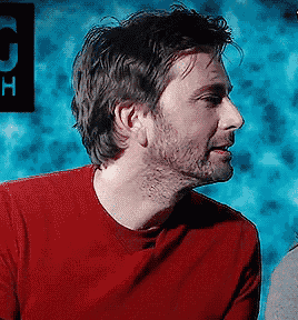 a man in a red shirt is looking to the side