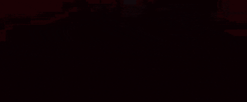 a person is standing in a dark room with red lights coming out of it .