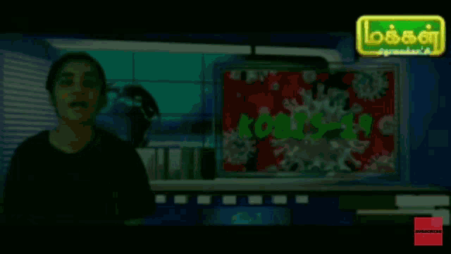 a woman stands in front of a screen that says ' covid-19 '