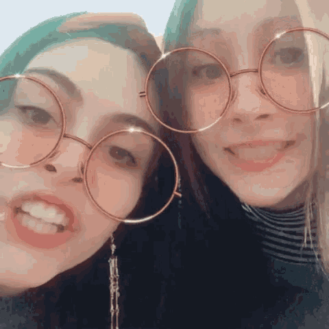 two girls wearing round glasses are posing for a picture together