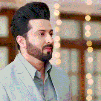 a man with a beard is wearing a suit and looking at the camera .