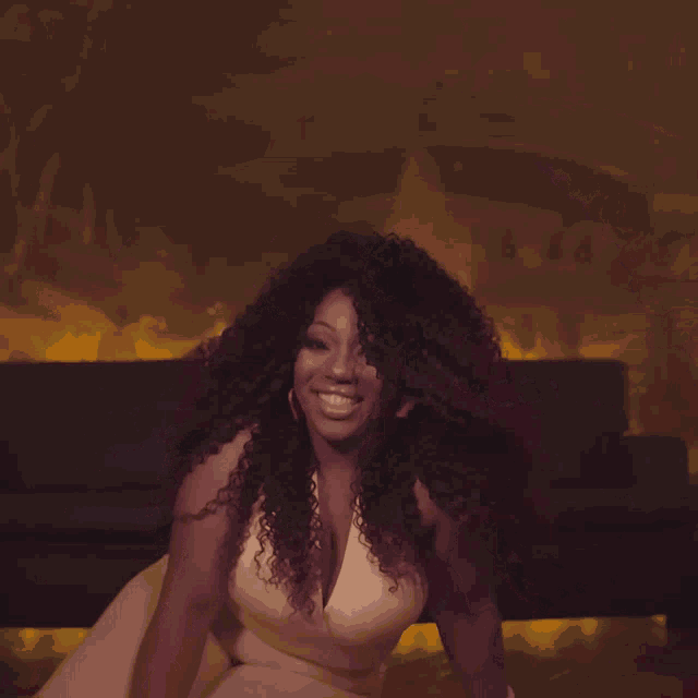 a woman with curly hair wearing a white dress