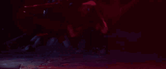 a close up of a person 's hand holding a purple object in a dark room .