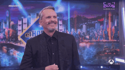 a man with a mustache is smiling in front of a sign that says el ho