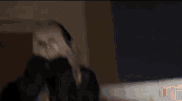 a girl with blonde hair and black nails is wearing headphones and covering her face with her hands