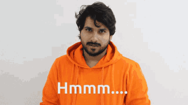 a man wearing an orange hoodie with the words hmm on it