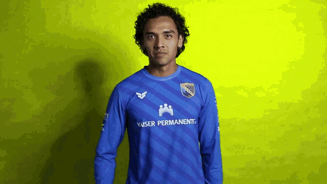a man wearing a blue shirt that says kaiser permanente on it