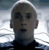 a close up of a bald man 's face with wires coming out of it .