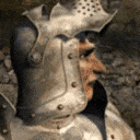 a close up of a person wearing a knight 's helmet and armor .