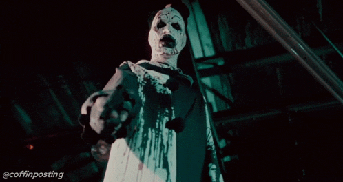 a clown is holding a gun in a dark room with the hashtag coffinposting