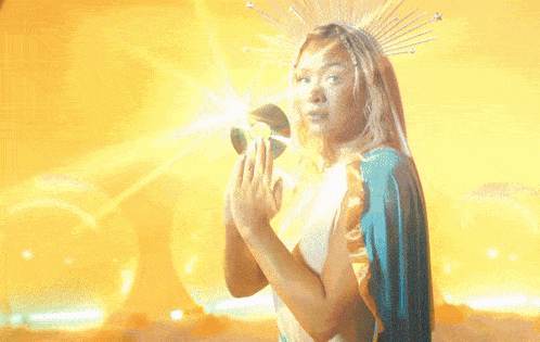 a woman with a blue cape and a crown on her head is praying