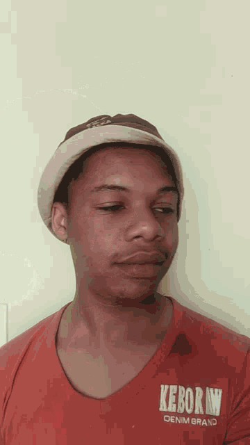 a man wearing a hat and a keborn shirt