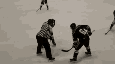 a group of hockey players are playing a game on a rink .