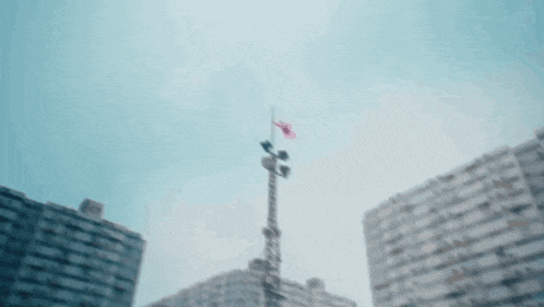 a red flag is flying in the wind in front of a building
