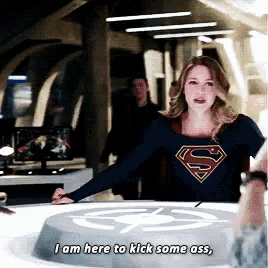 a woman in a superman shirt says i am here to kick some ass .