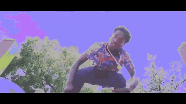 a man is kneeling down with his hands outstretched in front of a blue sky .