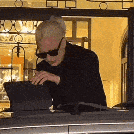 a man wearing sunglasses is looking at a tablet computer