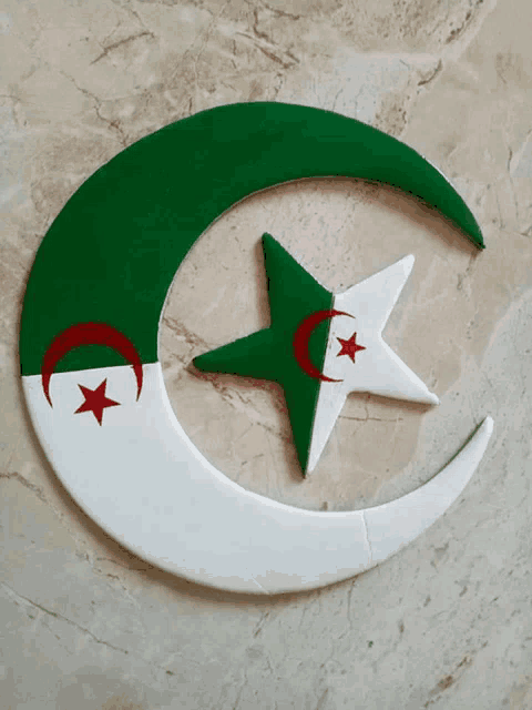 a green and white crescent moon with a red and white star on it