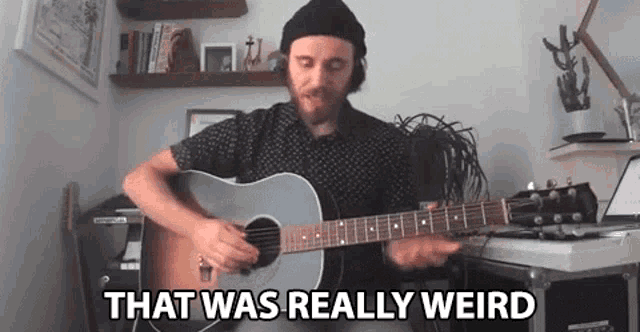a man is playing an acoustic guitar in a room and saying that was really weird .