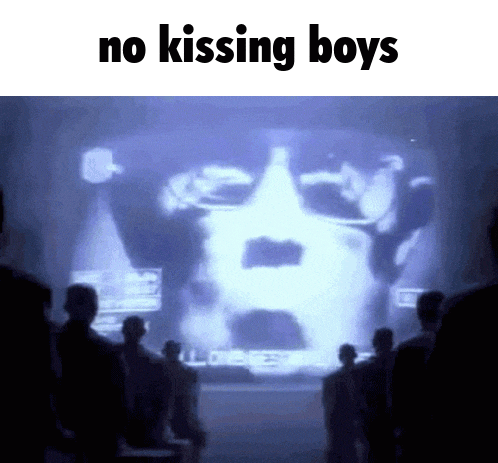 a group of people standing in front of a screen that says no kissing boys on it