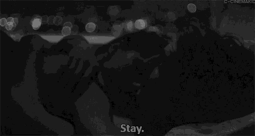 a black and white photo of a man and woman laying in bed with the words " stay " written below them