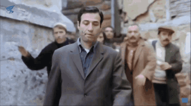 a man in a suit stands in a crowd of people