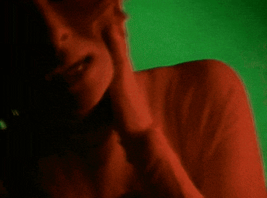 a woman in a red sweater is covering her face with her hand