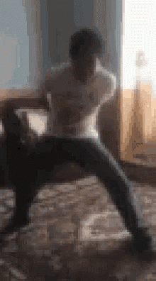 a blurry picture of a man in a white shirt and black pants standing on his knees .