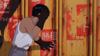 a man covering his face with his hands in front of a wall with chinese writing on it